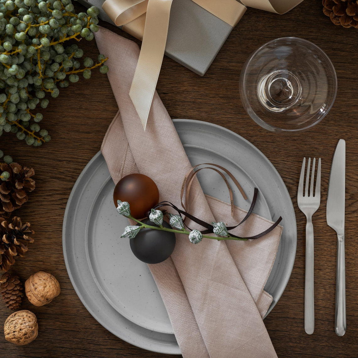 sophisticated holiday dinner place setting decorated with handblown glass ball ornaments