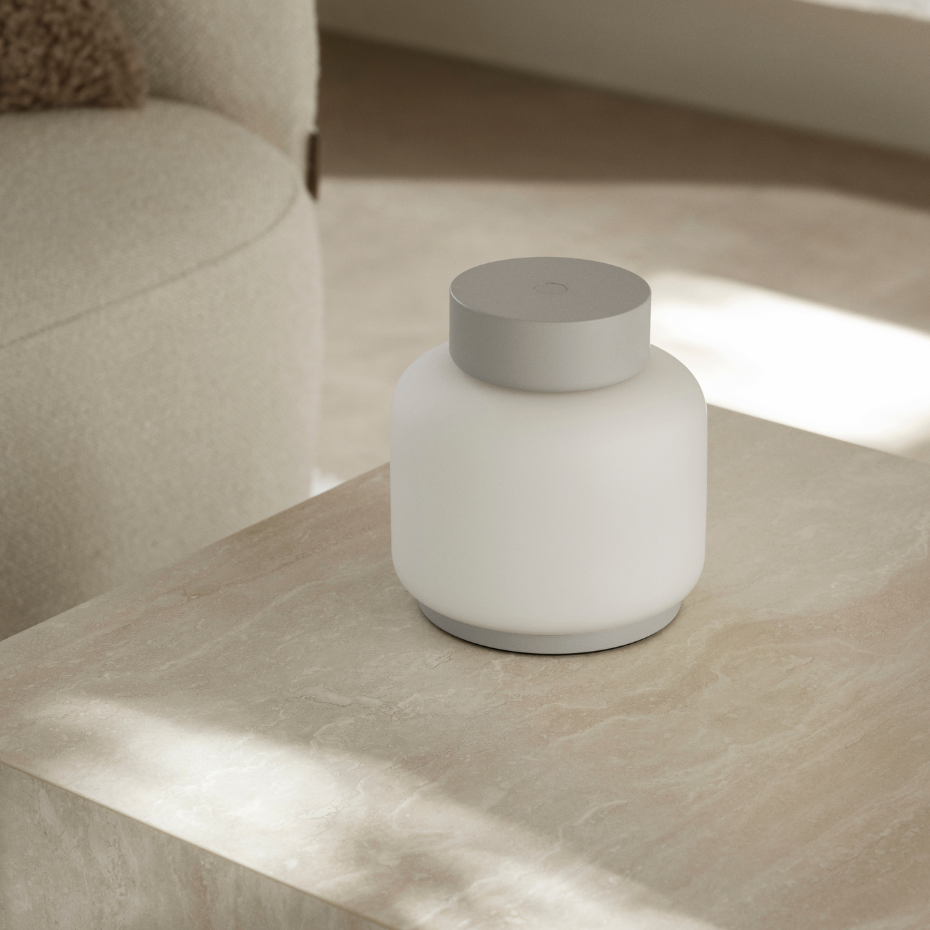 FAWN Lantern placed on a neutral coffee table indoors with a neutral chair in the background.