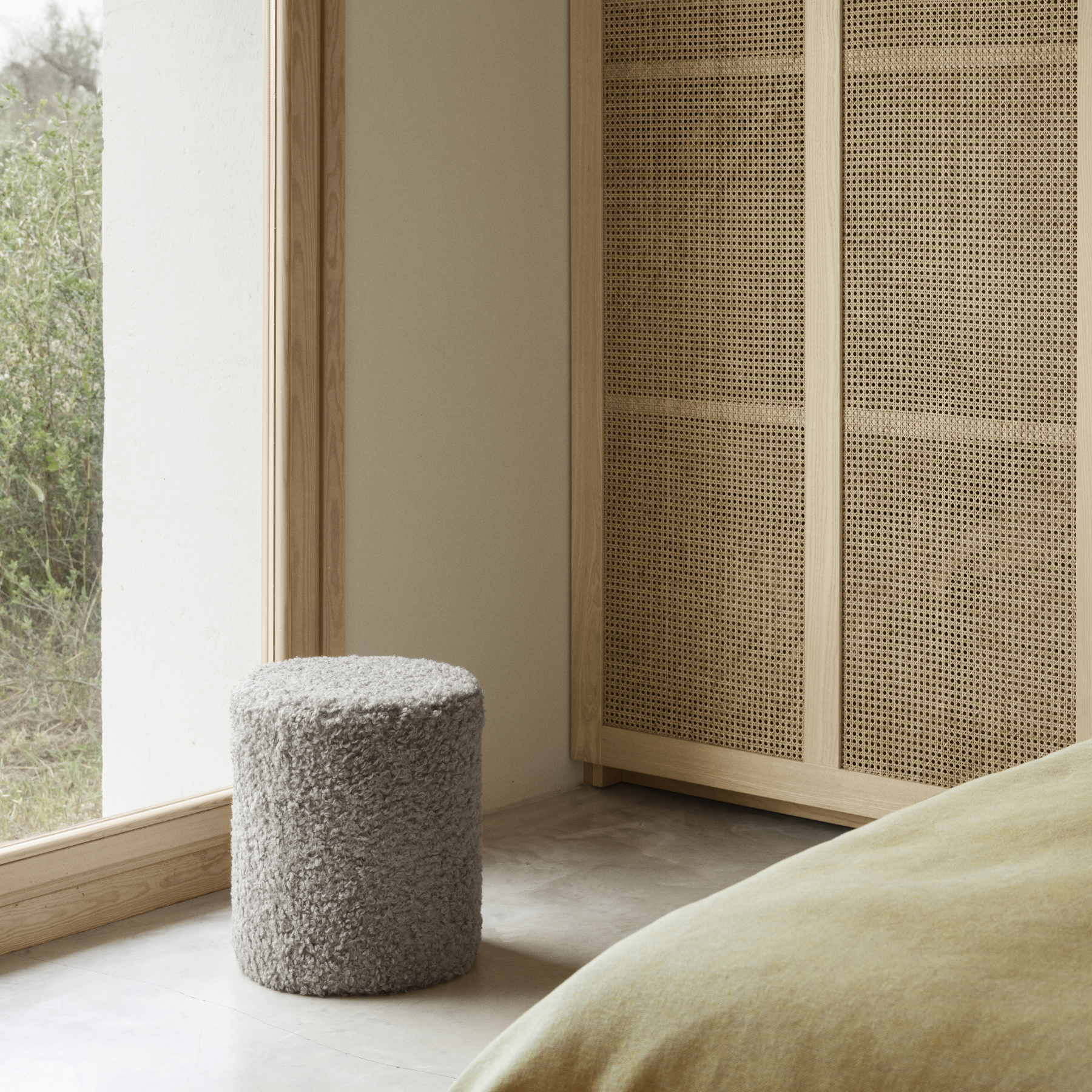 TEDDY Pouf shown in a bedroom with a bed and mid-century closet shown in the background.