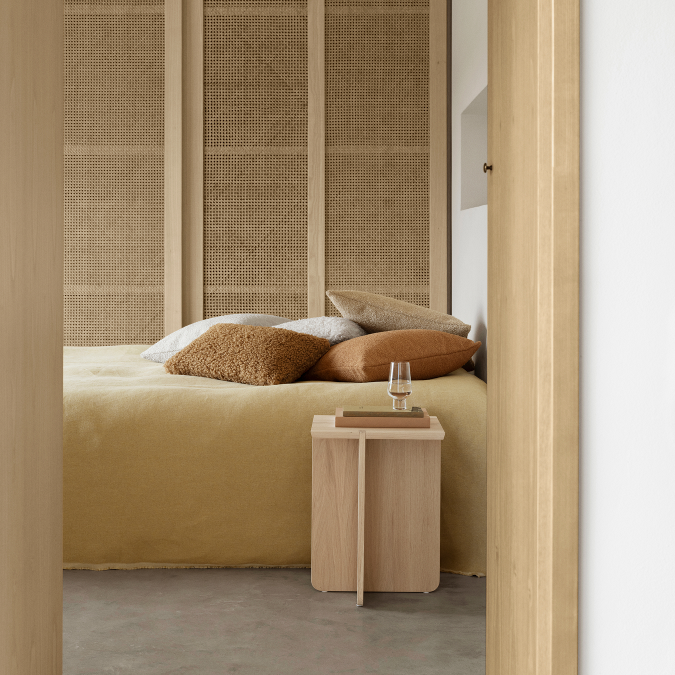 ENGAWA Oak Table used as a nightstand in a bedroom setting featuring concrete flooring and mid-century wall finishings.