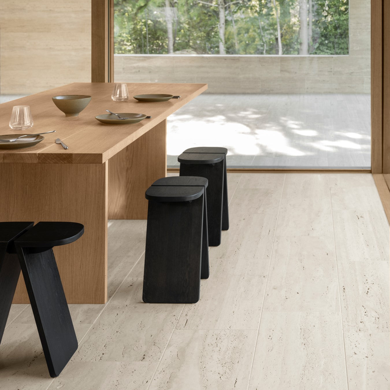 blomus AVIO solid oak stool in black around a modern dining table with Asian aesthetic