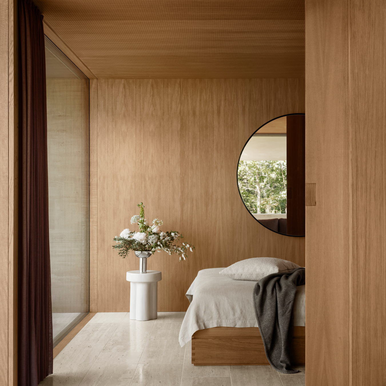 bedroom with contemporary wood walls and glazed ceramic TORU side table with flowers in a vase on top