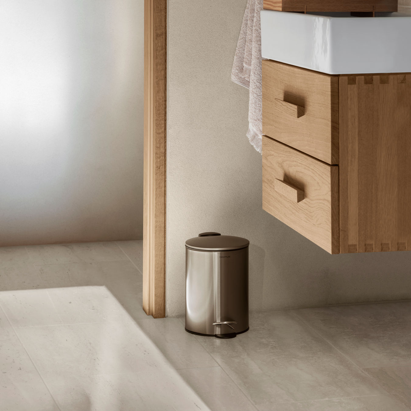 Scandinavian style bathroom with wooden drawers and brushed metal pedal bin