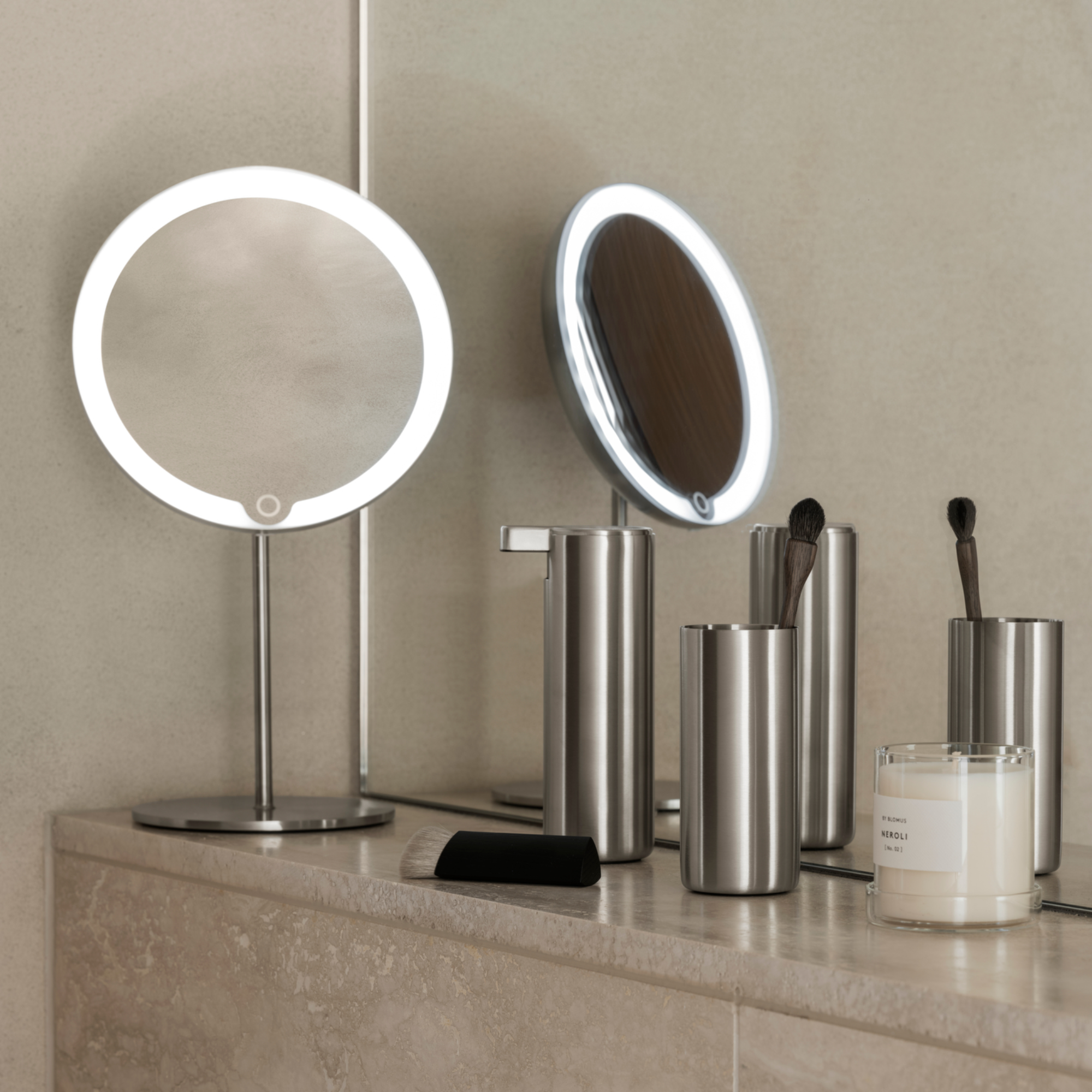 brushed stainless steel bathroom accessories on a minimalist marble counter top in a modern bathroom