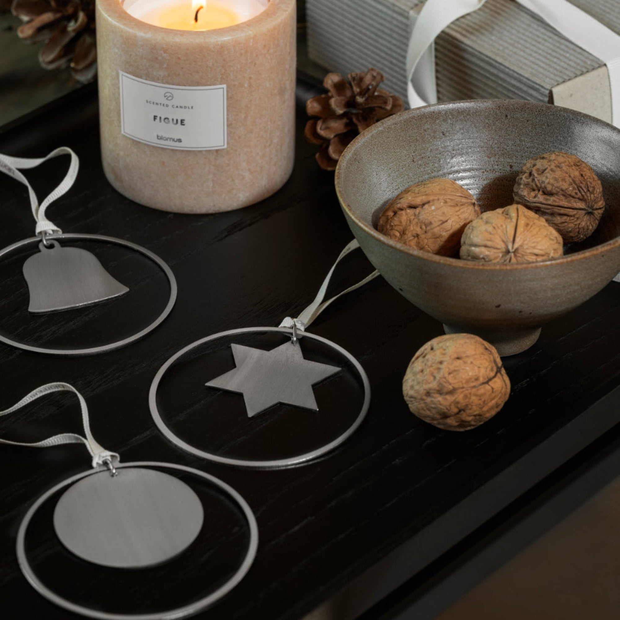 sofa table displaying a candle and bowl with walnuts next to modern classic stainless steel ornaments
