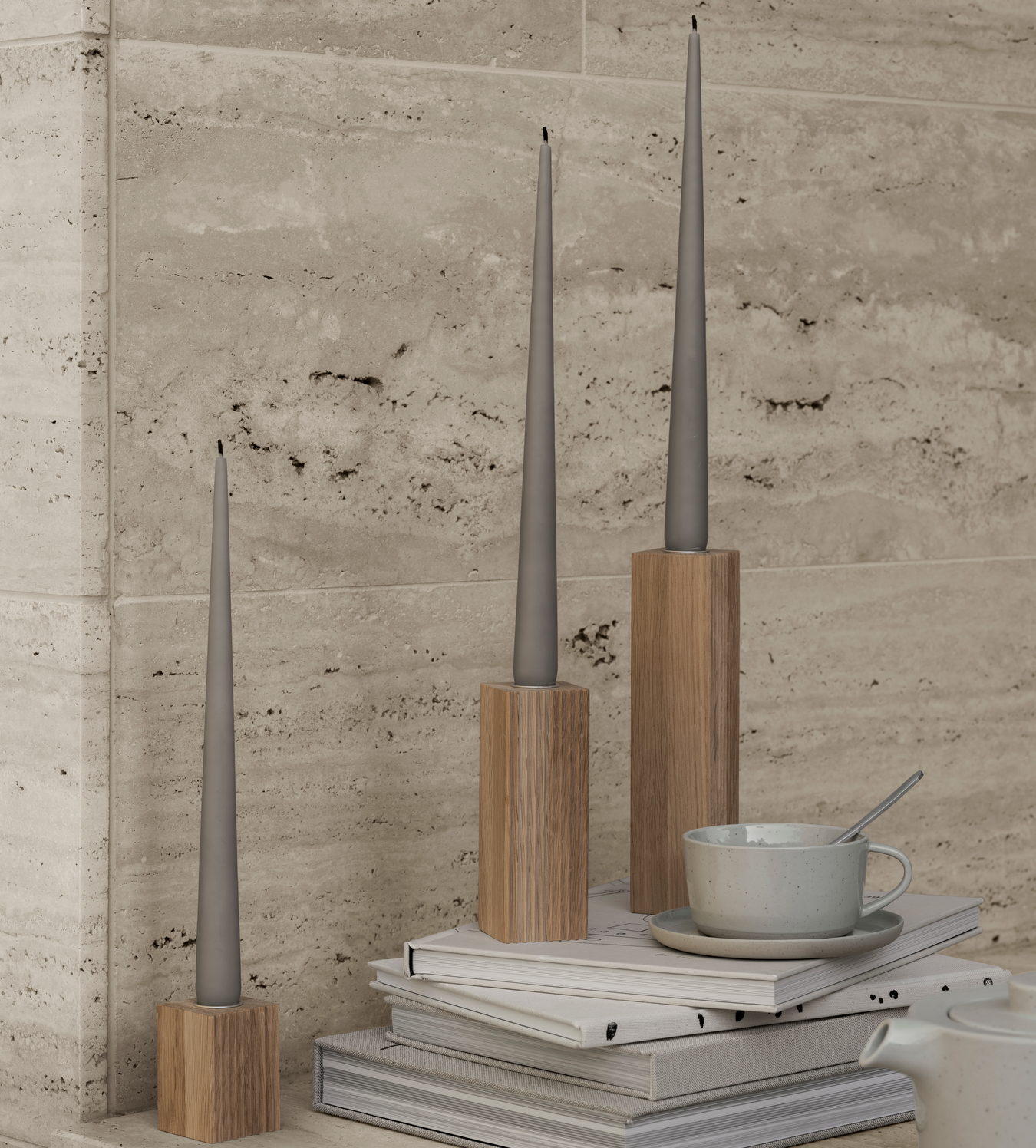 marble kitchen wall with ridged oak candle holders placed upon a stack of books