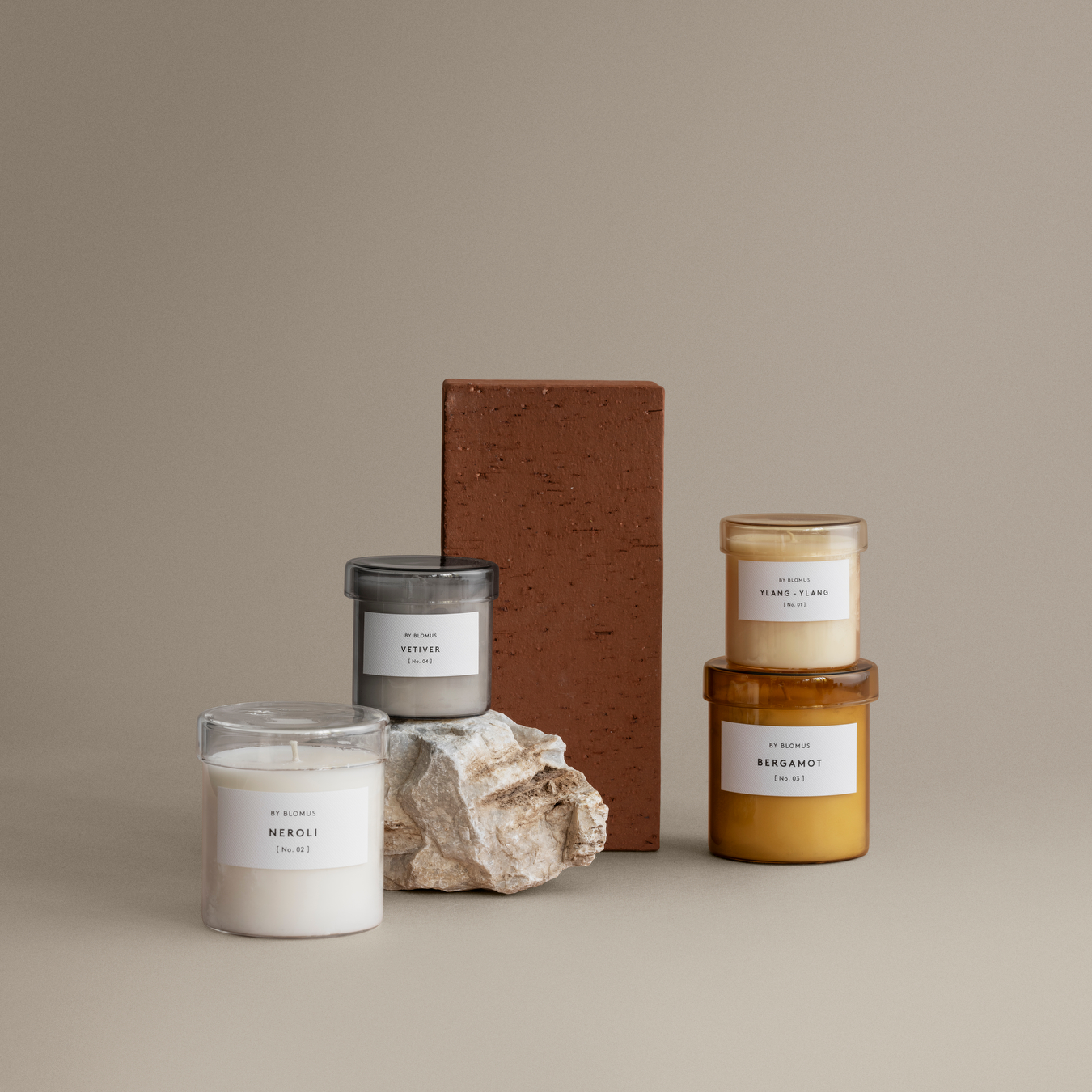 VALOA Candles shown together in a setting that contains a rock and a brick.