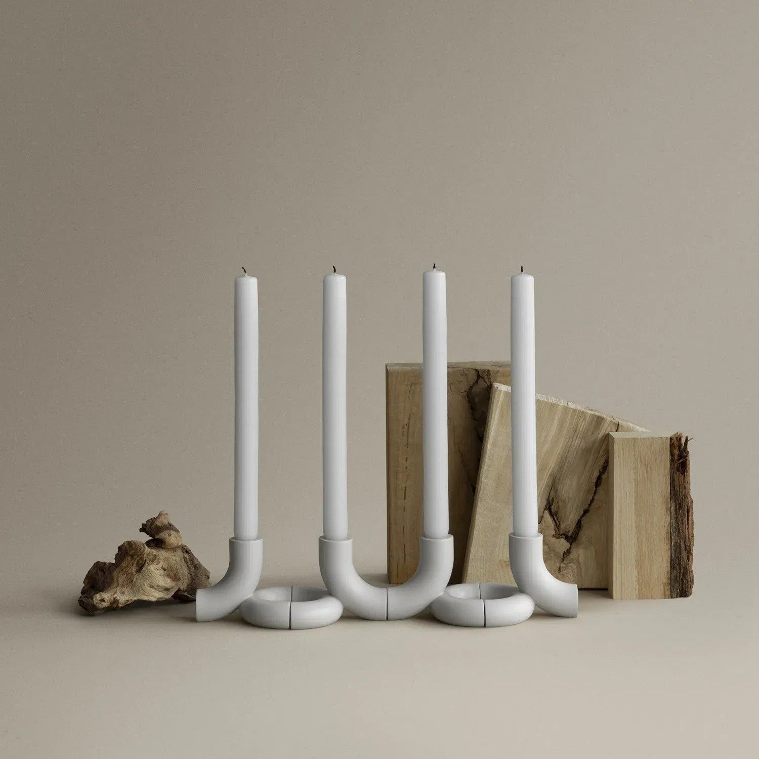 DOODLE Candle Holders with candles placed together with wood and stone in the background.
