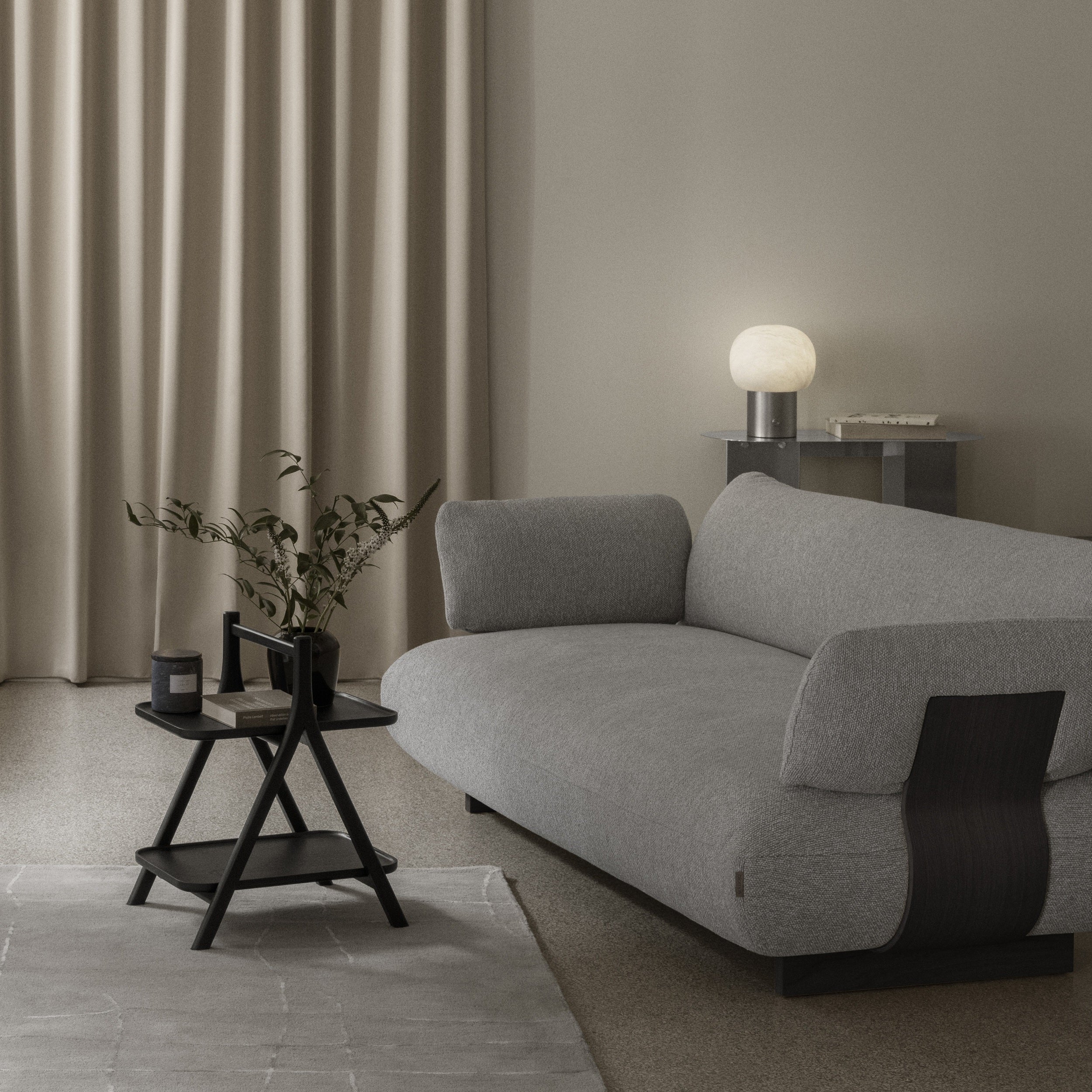 Gray sofa in a modern living room with a side table and lamp.