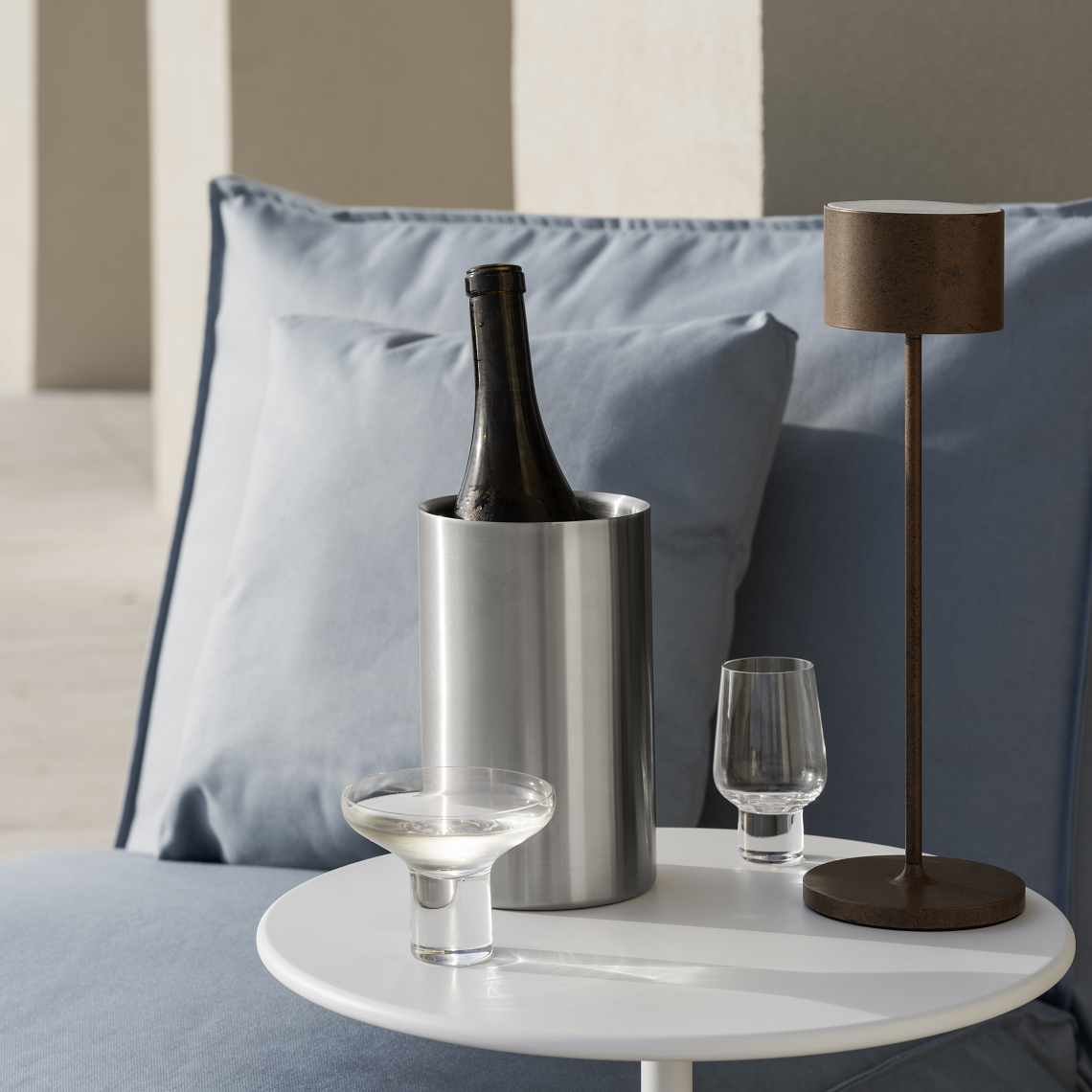 Outdoor lounge with wine cooler and outdoor table lamp on a side table
