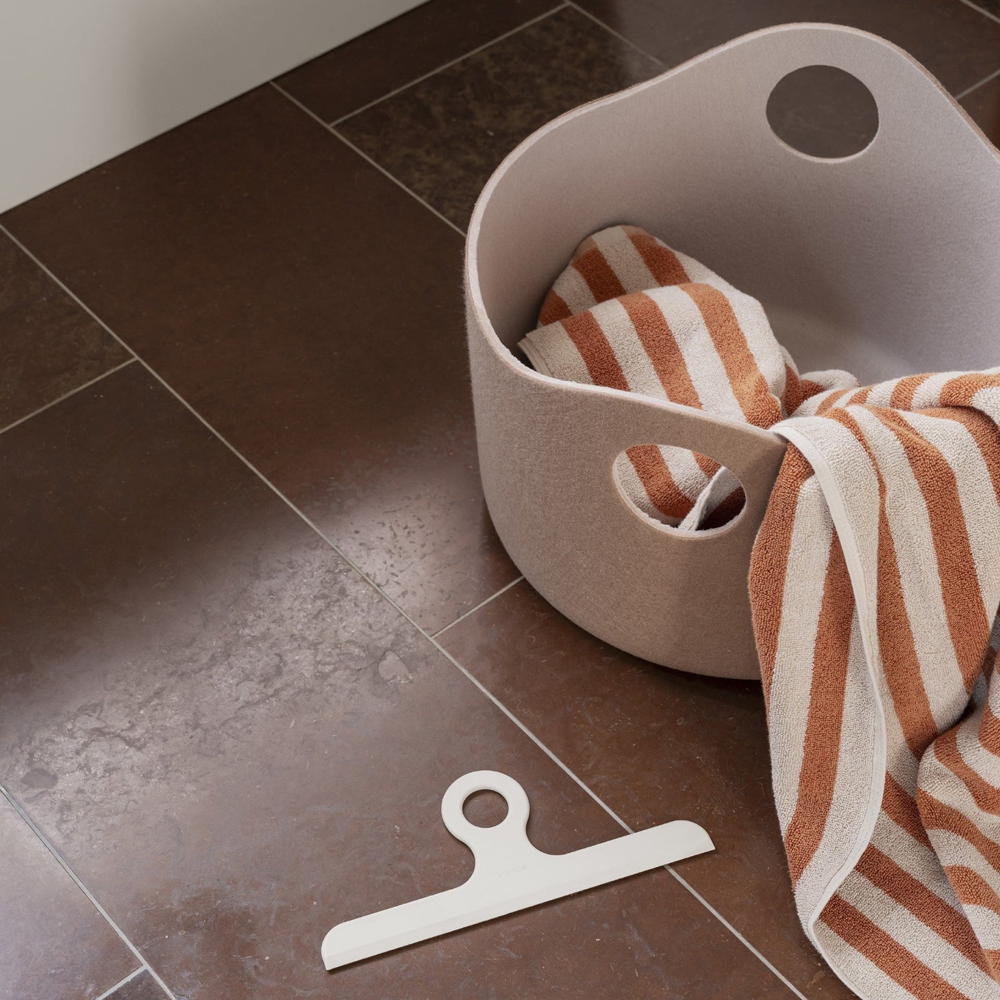simple silicone shower squeegee on red marble floors