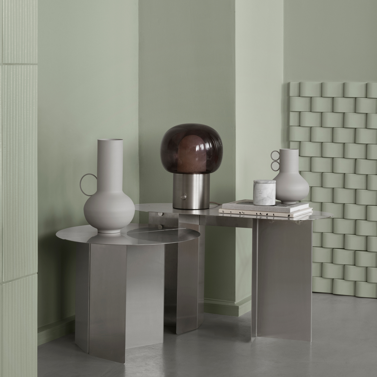 Sleek modern decor with LOHA jug vases featured on metal tables with a lamp and green walls
