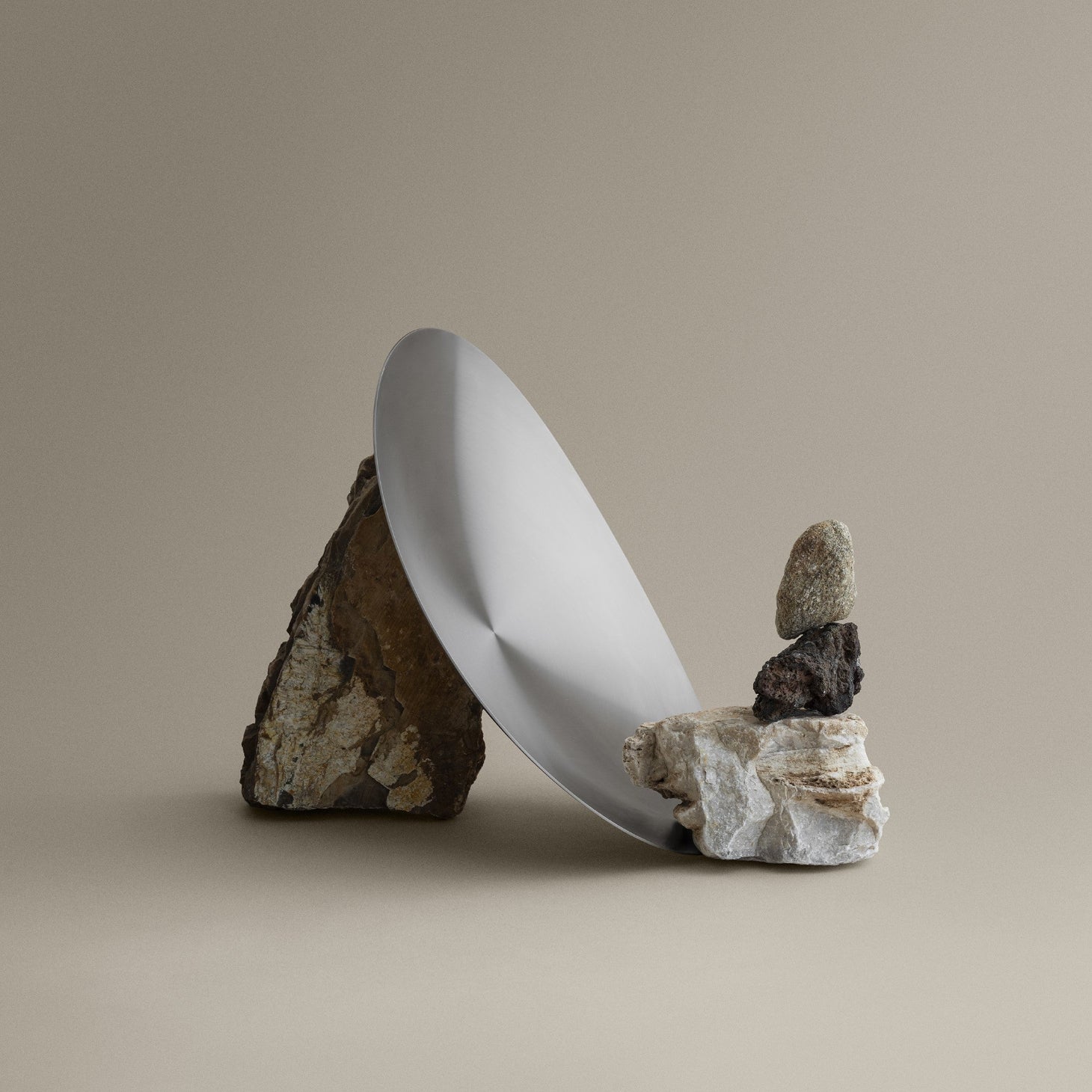 blomus ONDEA brushed stainless steel bowl arranged with colored rocks on a plain background