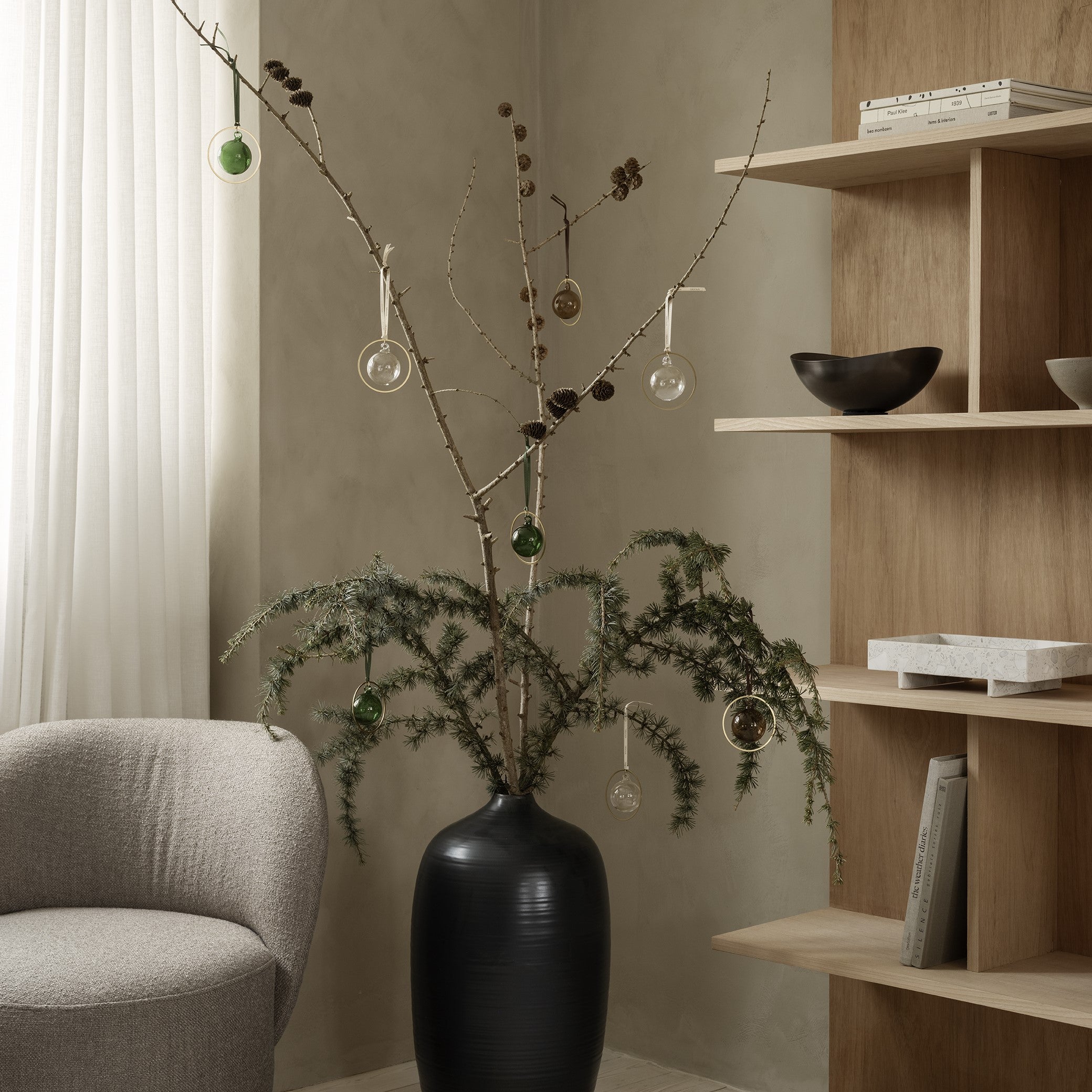 ONDEA burnt metal bowl displayed on wood shelf next to a modern Christmas tree