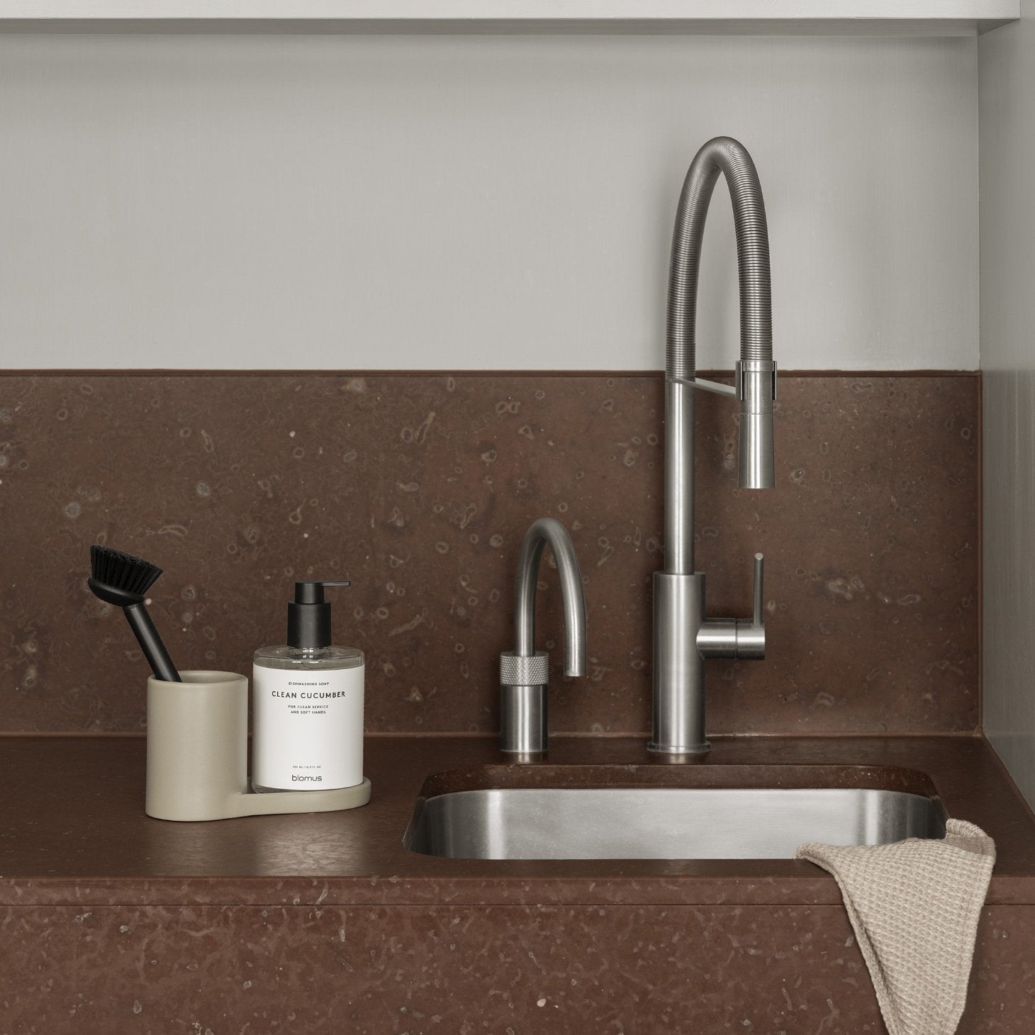 blomus PRIO sink caddy on rust colored marble countertop