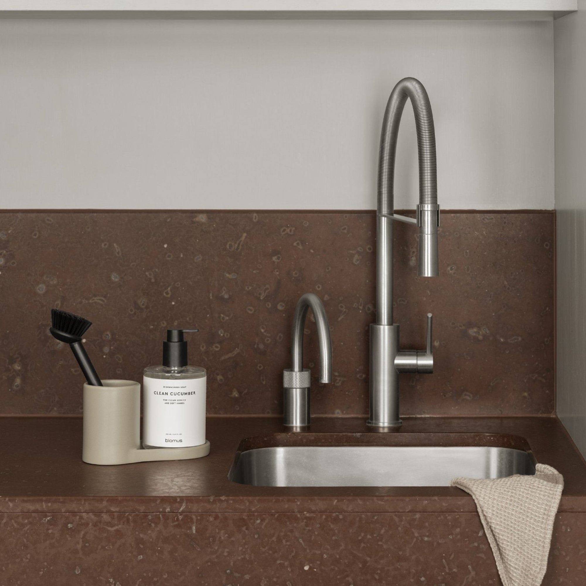 blomus PRIO sink caddy on rust colored marble countertop
