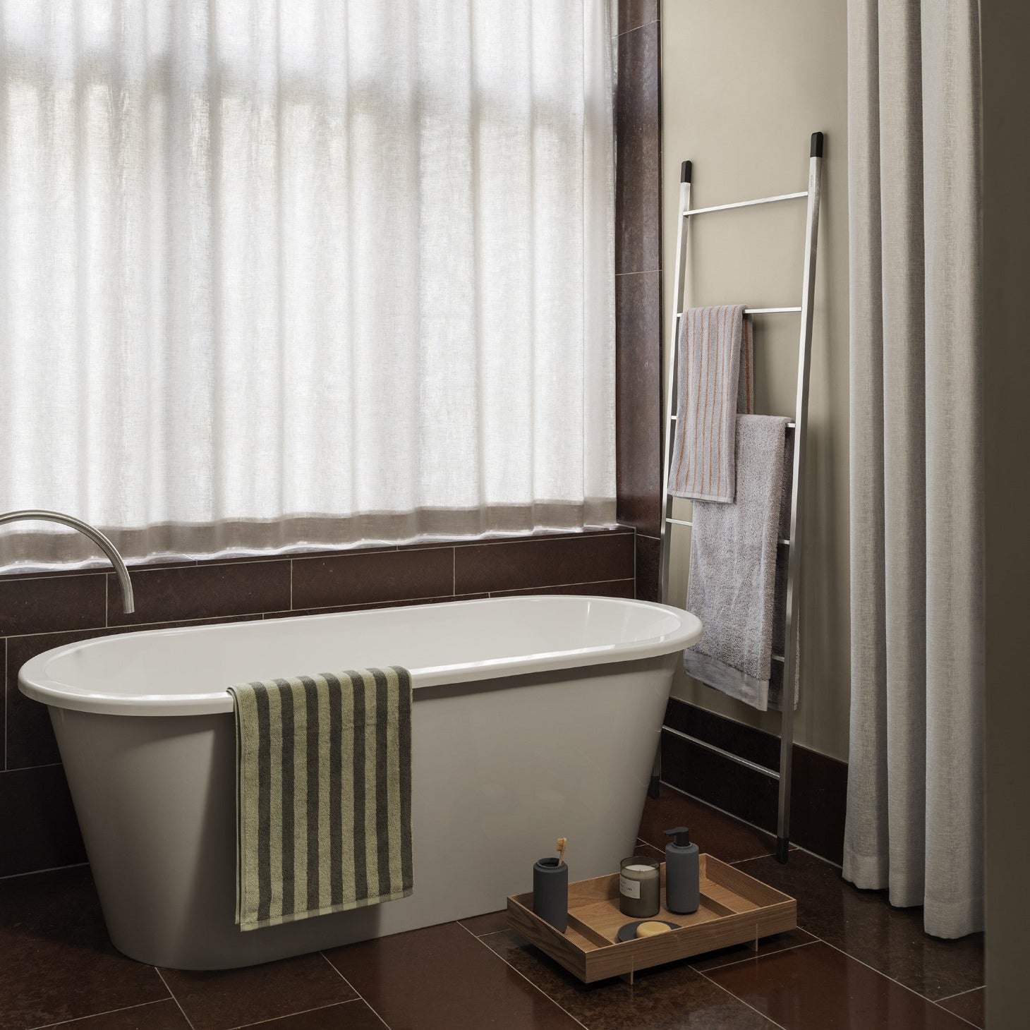Turkish cotton towels hanging by the washtub in a bathroom with red marble floors