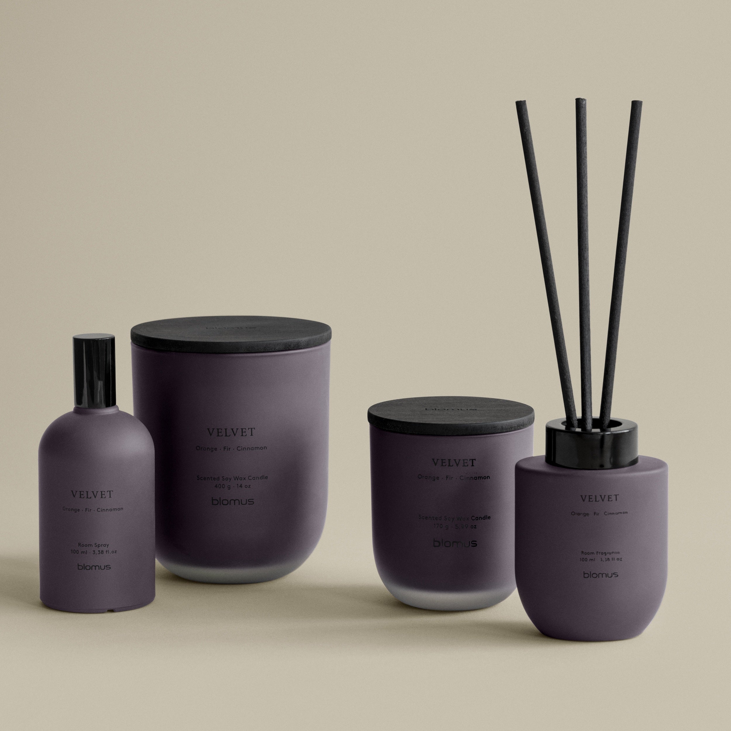 Set of purple and black home fragrance products on a beige background