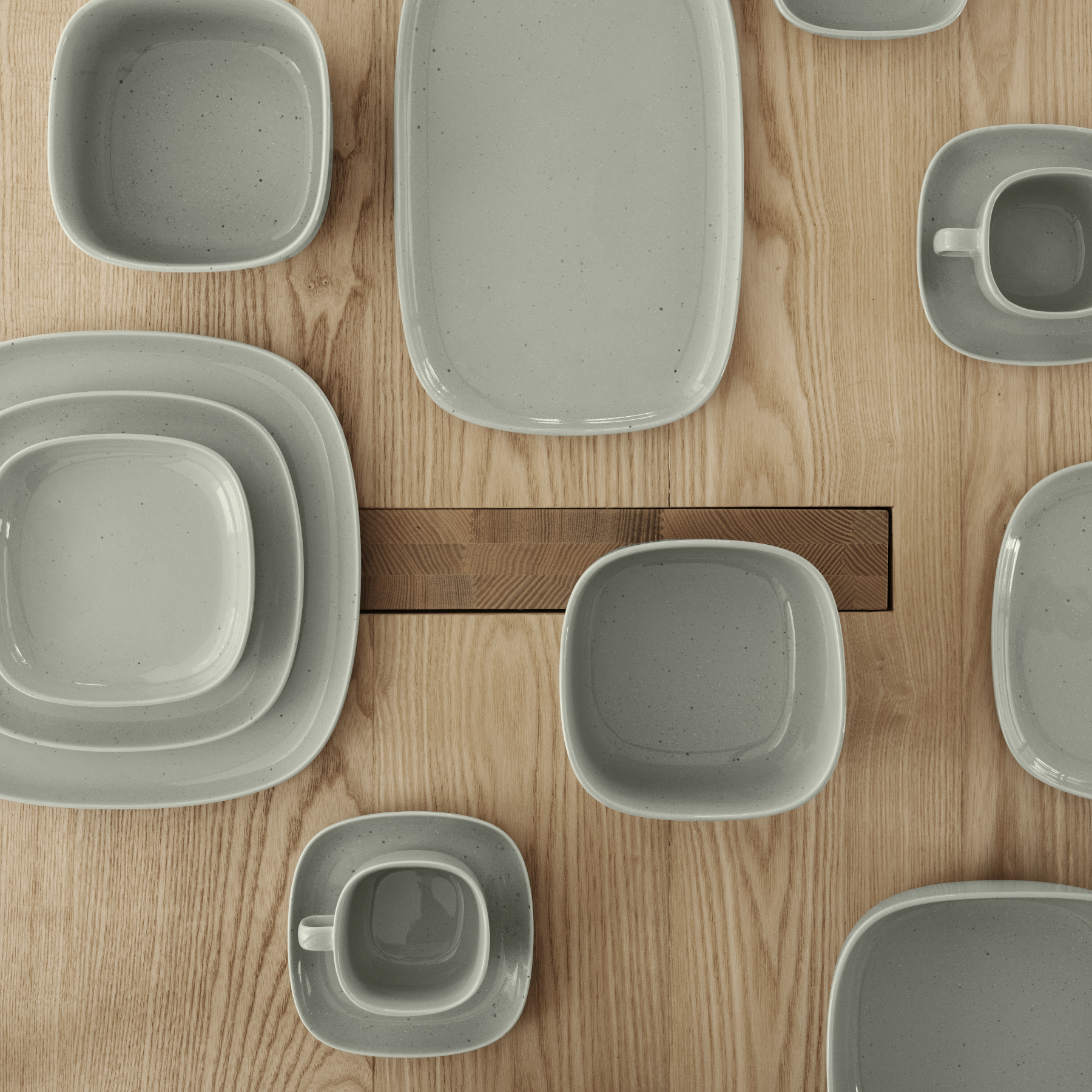 VAHLO Mirage Grey Dishes set on a wood table with the photo being taken from above.
