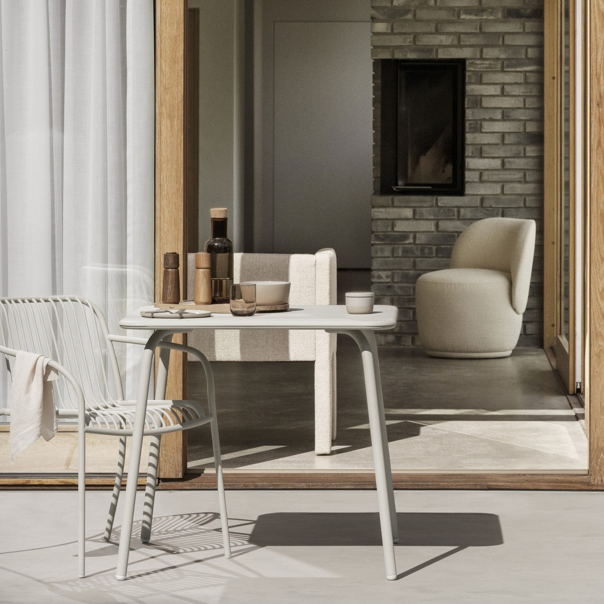 Patio scene with metal wire hair and square bistro table set for a casual outdoor meal