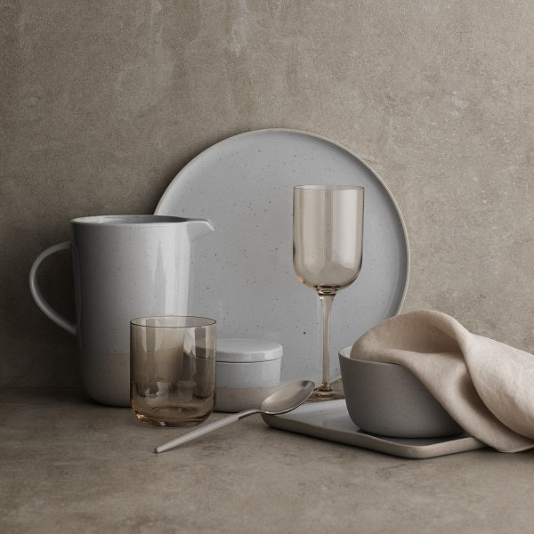 German designed blomus SABLO ceramic tableware stacked casually against a minimal concrete backdrop