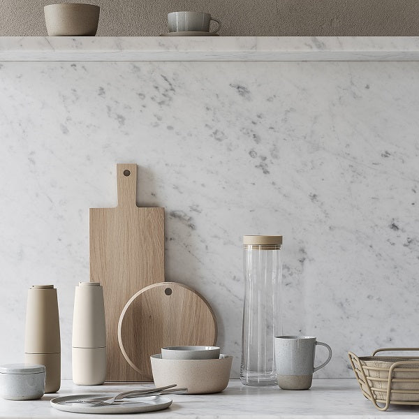 blomus SABLO minimalist stoneware arranged on a marble countertop with BORDA cutting boards and SPLASH carafe for the modern kitchen and sophisticated dining