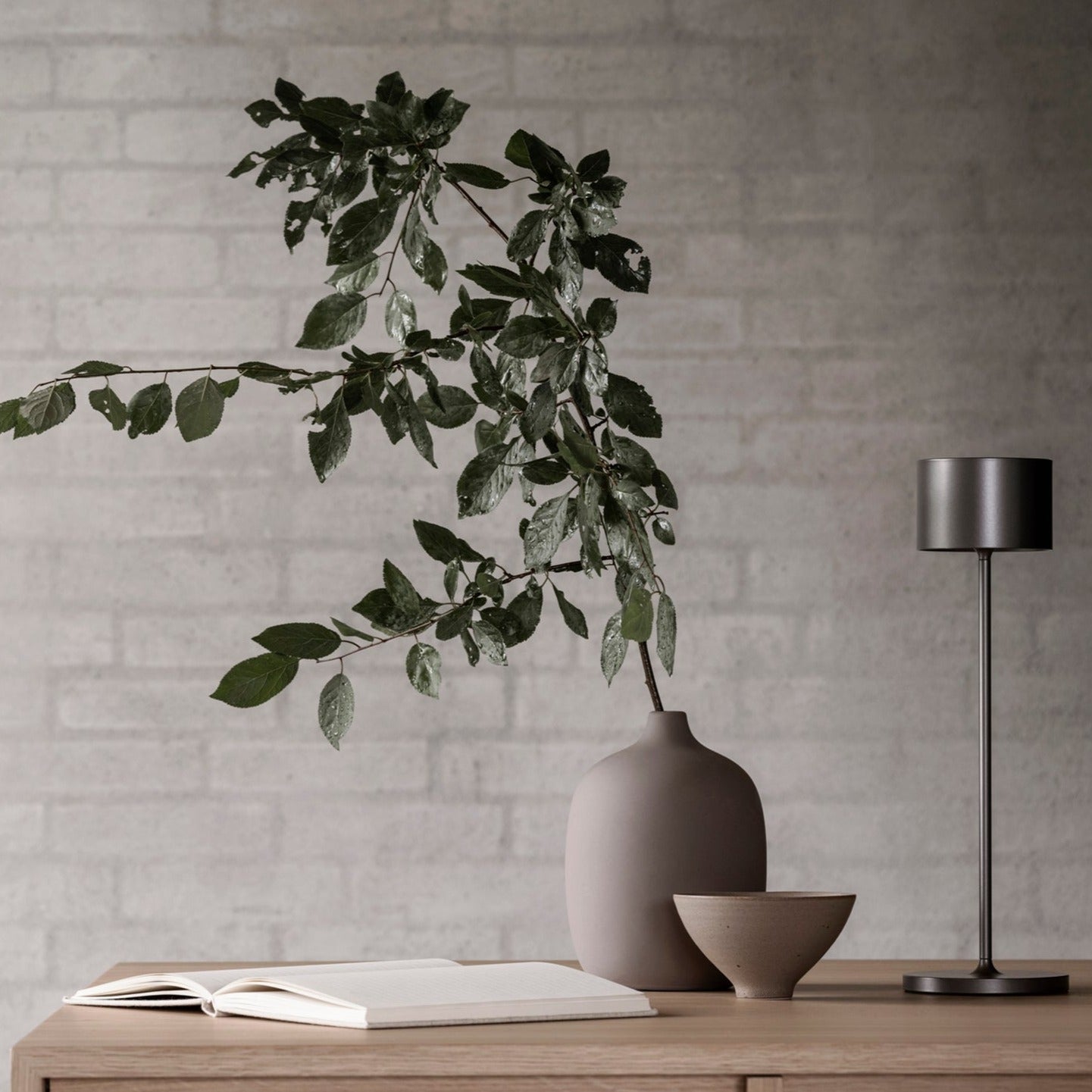 Minimalist study area with plant in a vase and light from an led table lamp