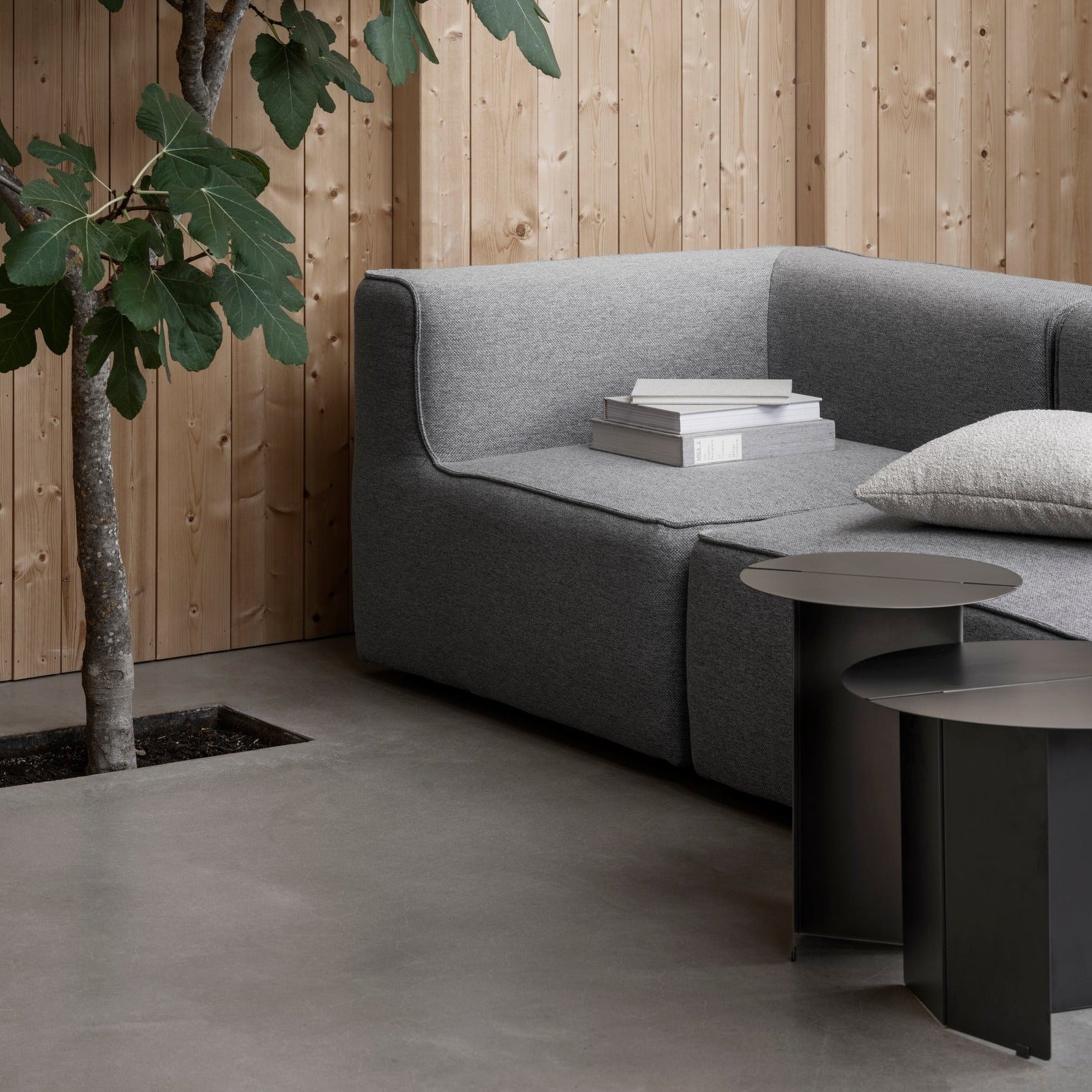 Japanese inspired sitting area with couch and two ORU metal side tables by blomus
