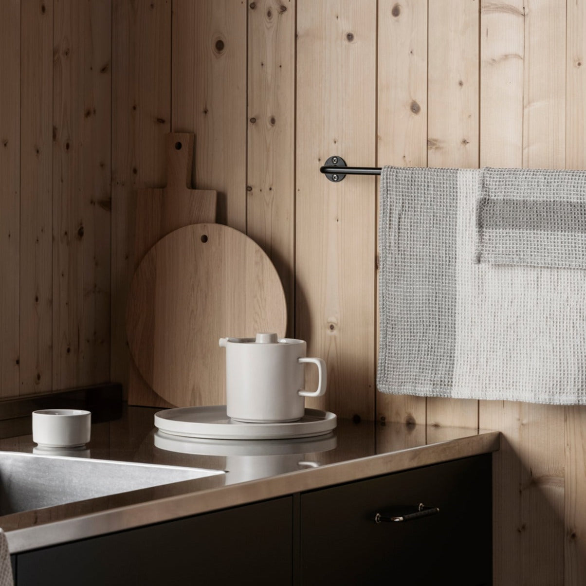 blomus GANO cotton waffle tea towels hanging next to a sink in minimalist kitchen