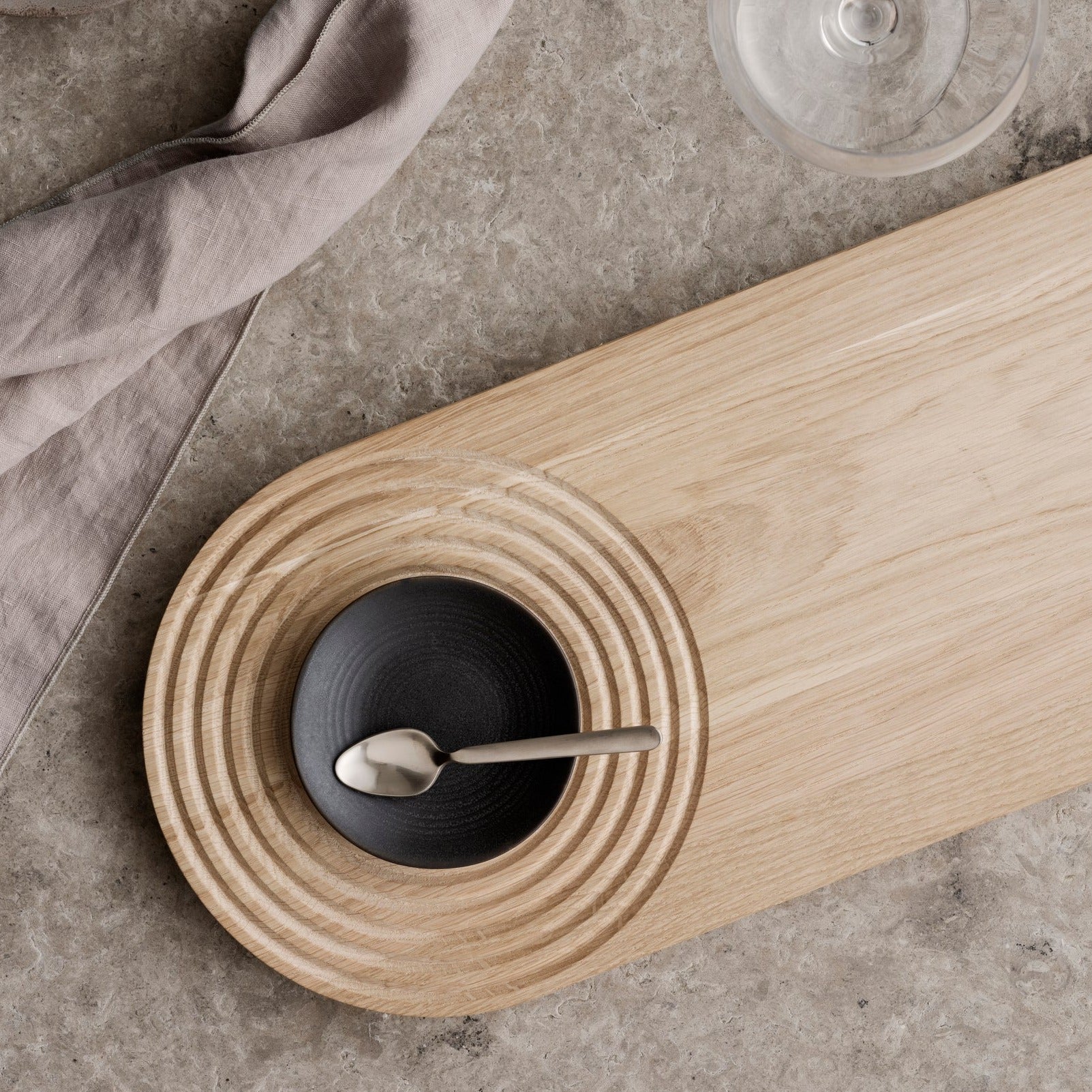 blomus ZEN Japanese inspired cutting board with small condiment bowl on a natural stone surface