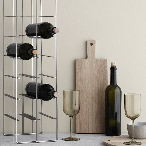 oak cutting board from BORDA collection by blomus leaning next to a wine bottle and glasses on a white marble counter
