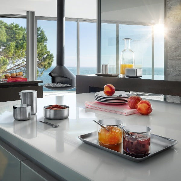 Modern kitchen with ocean views showcasing blomus BASIC stainless steel tray with breakfast items on a chic white counter