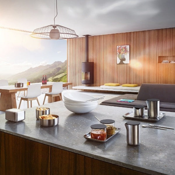 modern dining room with mountain views and kitchen island set for breakfast with blomus BASIC stainless steel tray and containers