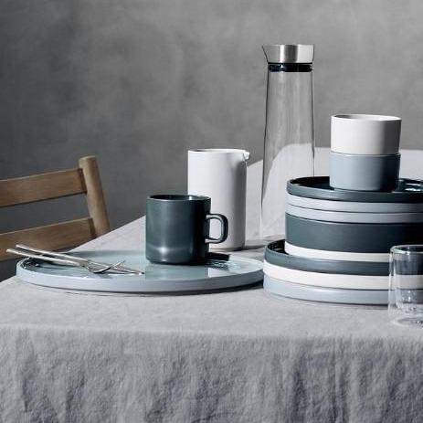 Scandinavian inspired stackable PILAR stoneware arranged on a minimalist dining table with grey tablecloth