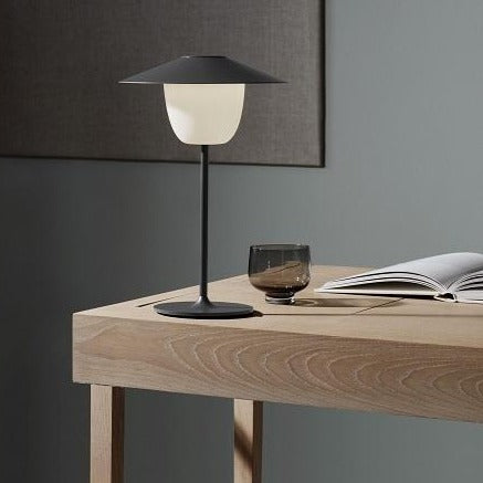 Modern study with wooden desk and warm glow from rechargeable table lamp