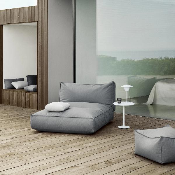 Chic outdoor seating area with white round side table on a wooden patio