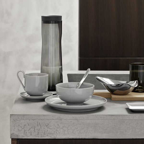 Natural stone kitchen counter featuring porcelain dishes and CALLISTA polished stainless steel lemon squeezer from blomus