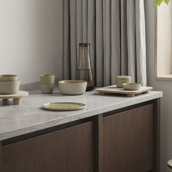 blomus BELO colored glass water carafe arranged on a minimalist marble counter with stoneware dishes