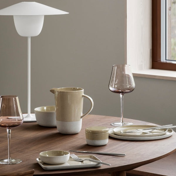 Savannah beige SABLO stoneware plates and bowls arranged in a modern lifestyle setting with BELO glassware