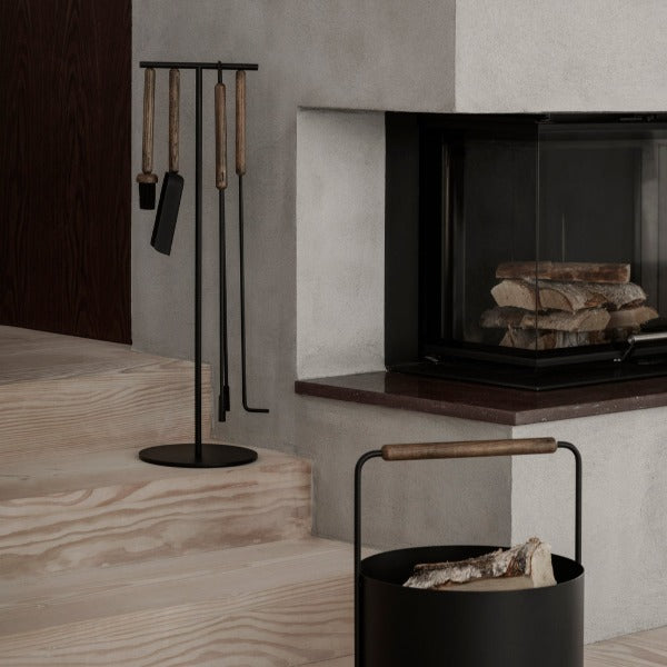 unfinished wooden staircase and modern fireplace with fireplace tool set and wood basket from blomus