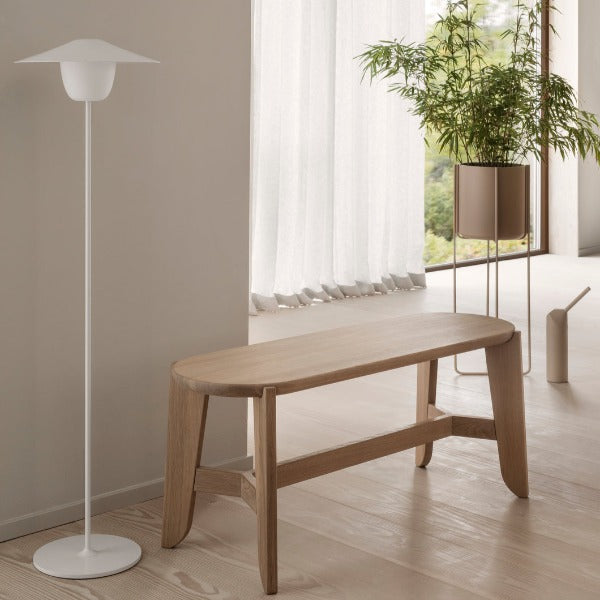 blomus ELI oak hallway bench next to a lamp and potted plant