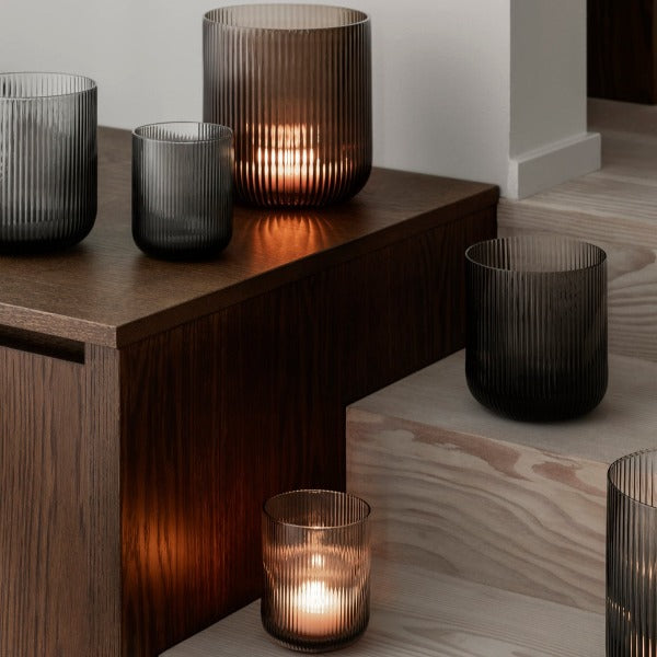 warm glow of light from colored glass hurricane lamps from blomus VEN collection