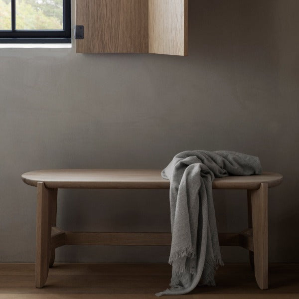 ELI Oak Bench with wool throw next to a window in a naturally lit room