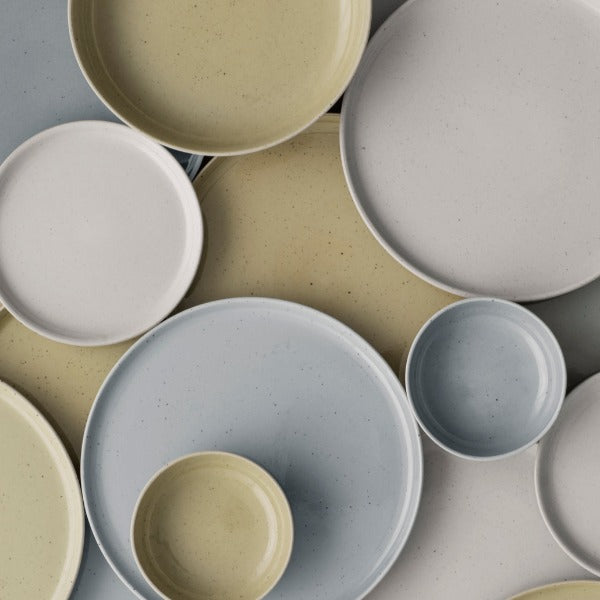 Assortment of blomus SABLO ceramic dinnerware displaying the glossy speckled glazed surface of the various colors