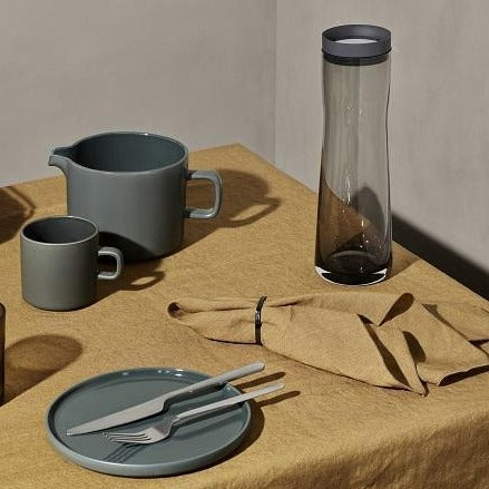 blomus SPLASH smoked glass water carafe displayed in minimalist dining place setting