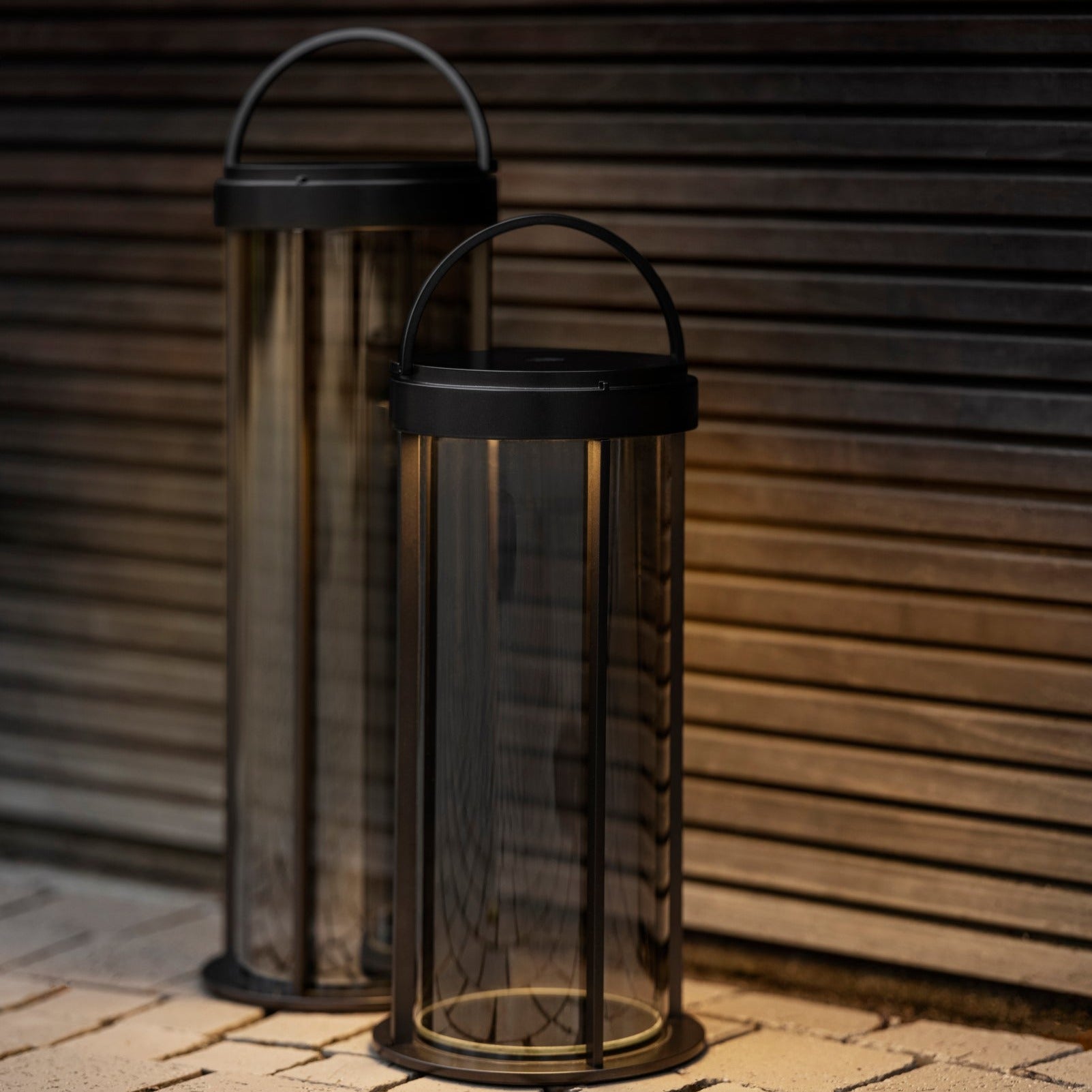 LED lanterns with warm natural glow on brick patio