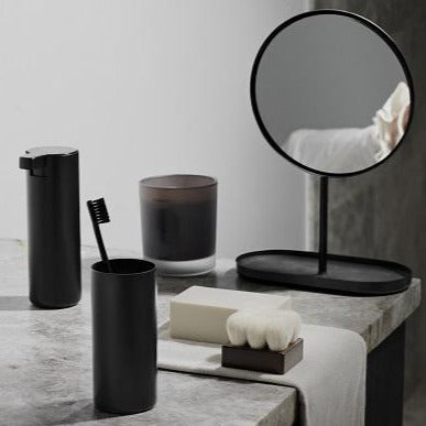 Elegant bathroom accessories in black titanium coated metal on a marble countertop