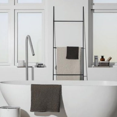 modern bathroom with minimalist metal towel ladder leaning against wall