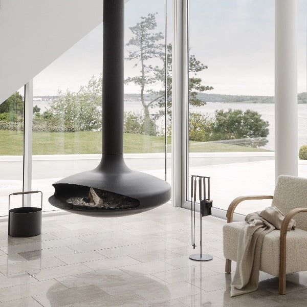 ultra modern elliptical fireplace over marble floors with ASHI fireplace accessories by blomus