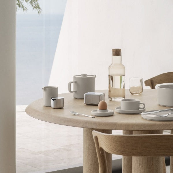 blomus PILAR Scandinavian minimalist inspired stoneware collection arranged on a modern white oak dining table in front of a large window